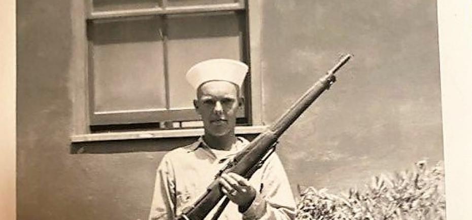 Earl Frieden is pictured at age 19 during boot camp in San Diego. In this black-and-white photo, he wears a new sailor's uniform and holds a 30-caliber gun