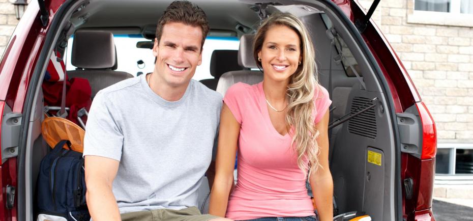 young couple sitting in tailgate of vehicle