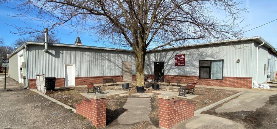 The backside of this commercial building for sale in Geneva features a small courtyard and seating area. 