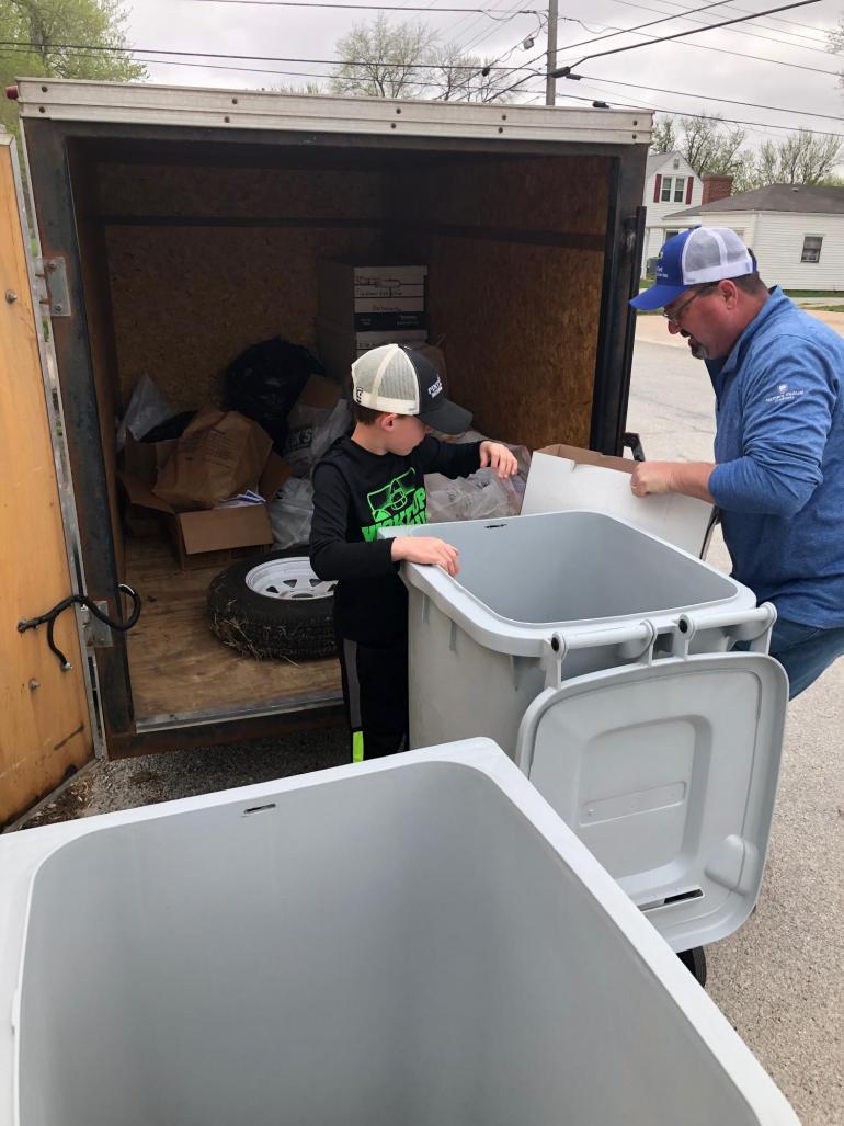 A Fortify employee and his grandson unload paper products (gathered in shickley) from an enclosed trailer.