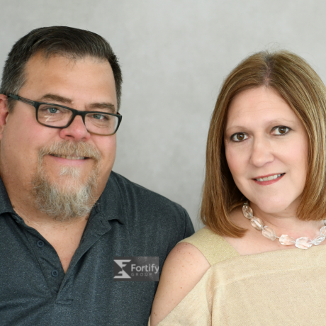 Jim and Kate Manes (new members of the Fortify Group team) are pictured. Jim is wearing a dark gray polo and kate is wearing a pale cream sweater.