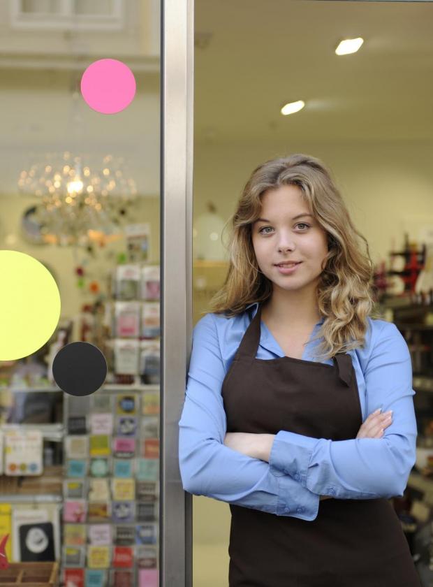 female owner standing in front of shop