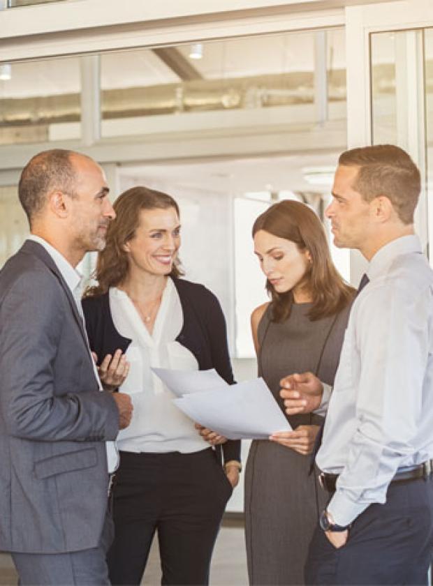 four people conducting a standing meeting